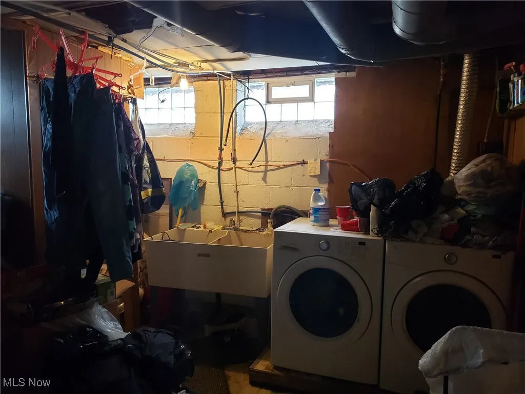 Laundry area featuring washer and dryer and concrete block wall