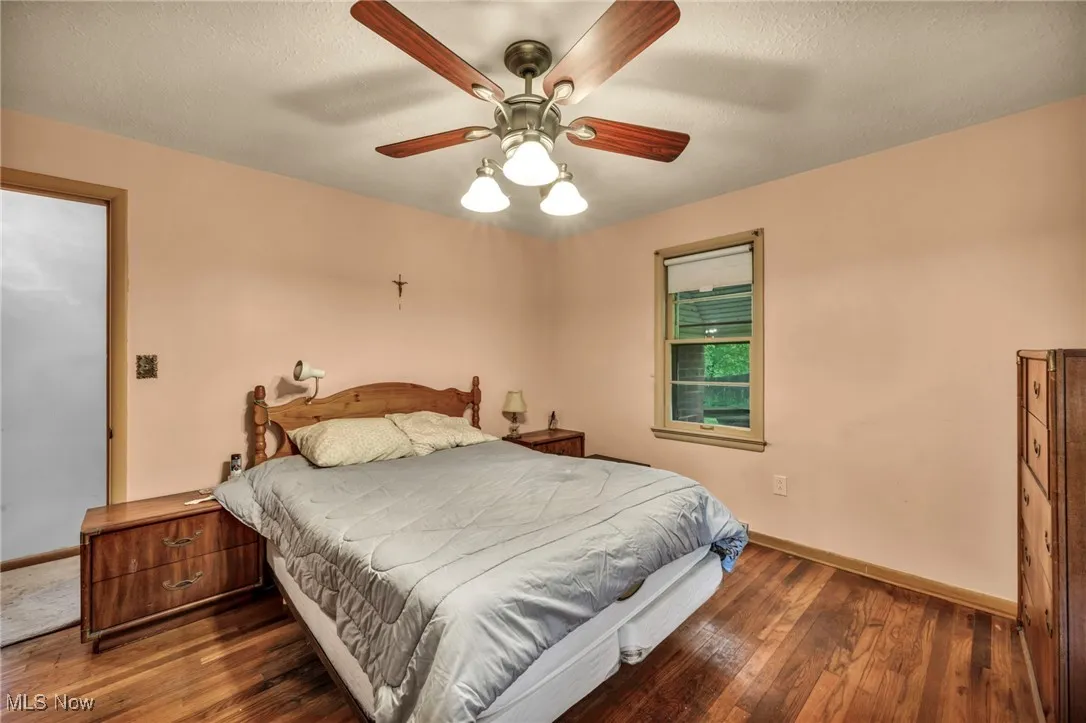 Bedroom featuring baseboards, wood-type flooring, and ceiling fan