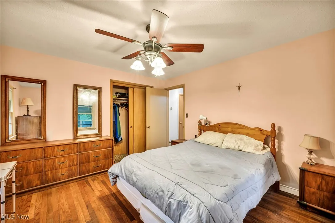 Bedroom with wood finished floors, a closet, and a ceiling fan