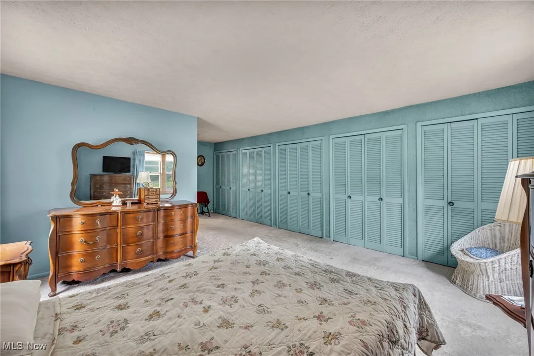 Carpeted bedroom featuring two closets and a textured ceiling