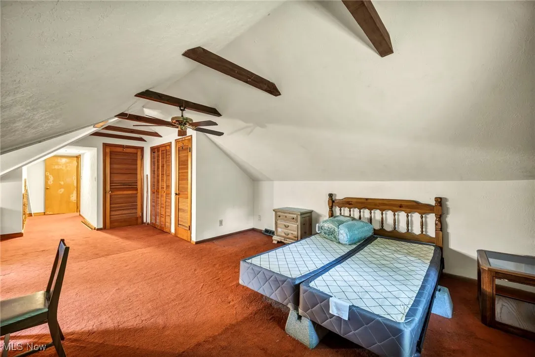 Bedroom with carpet, vaulted ceiling, ceiling fan, and baseboards