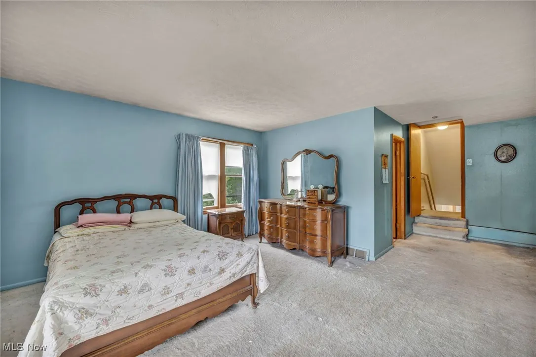 Carpeted bedroom with baseboards and a textured ceiling