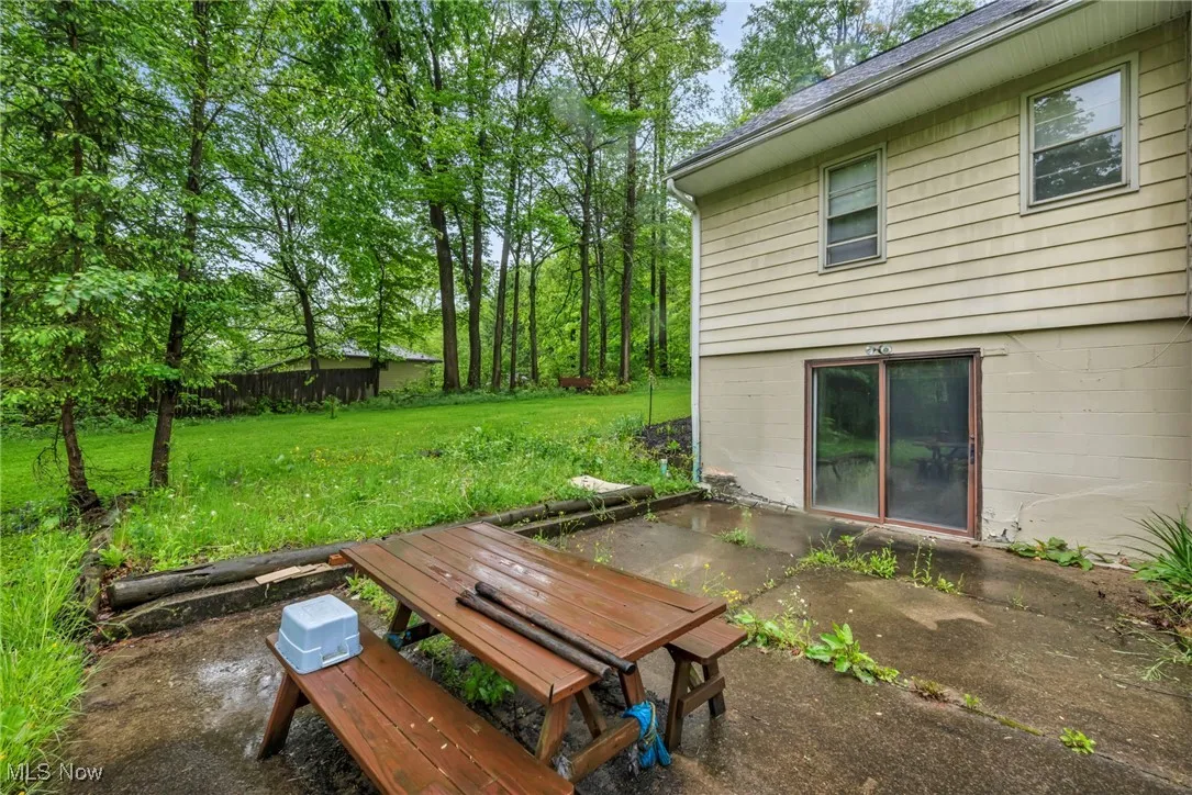View of grassy yard featuring a patio and outdoor dining area
