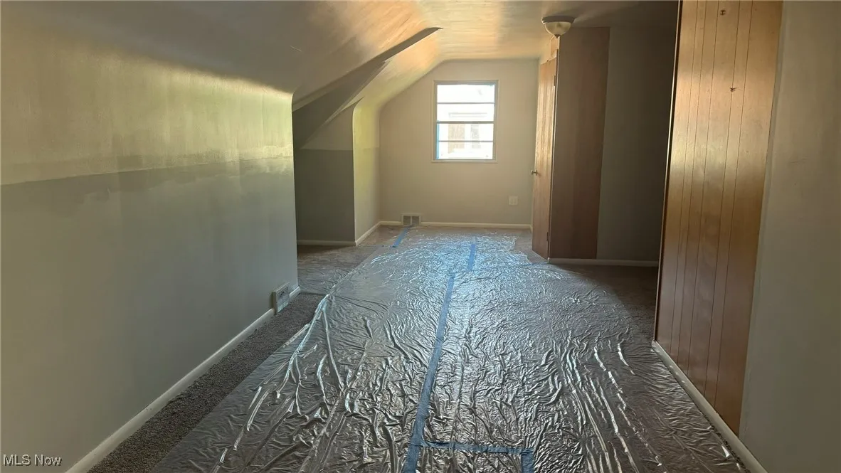 Bonus room featuring lofted ceiling and baseboards