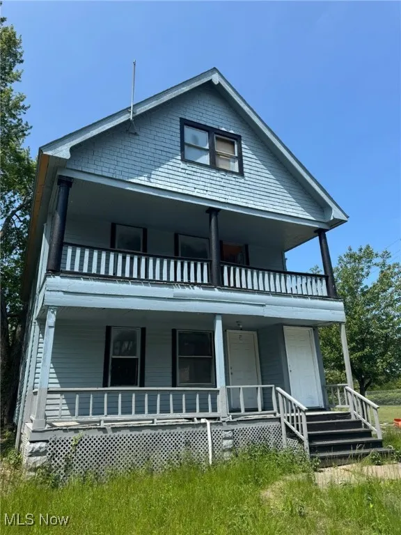View of front of house featuring a balcony and covered porch