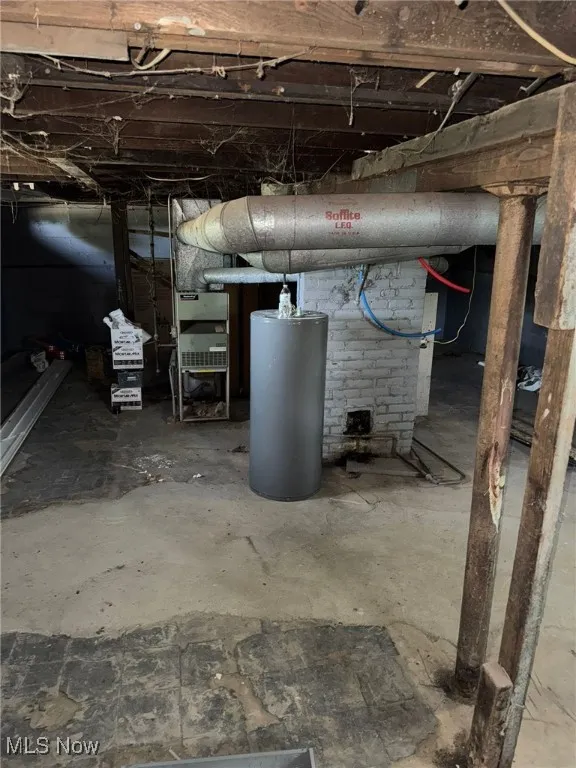Unfinished below grade area featuring water heater
