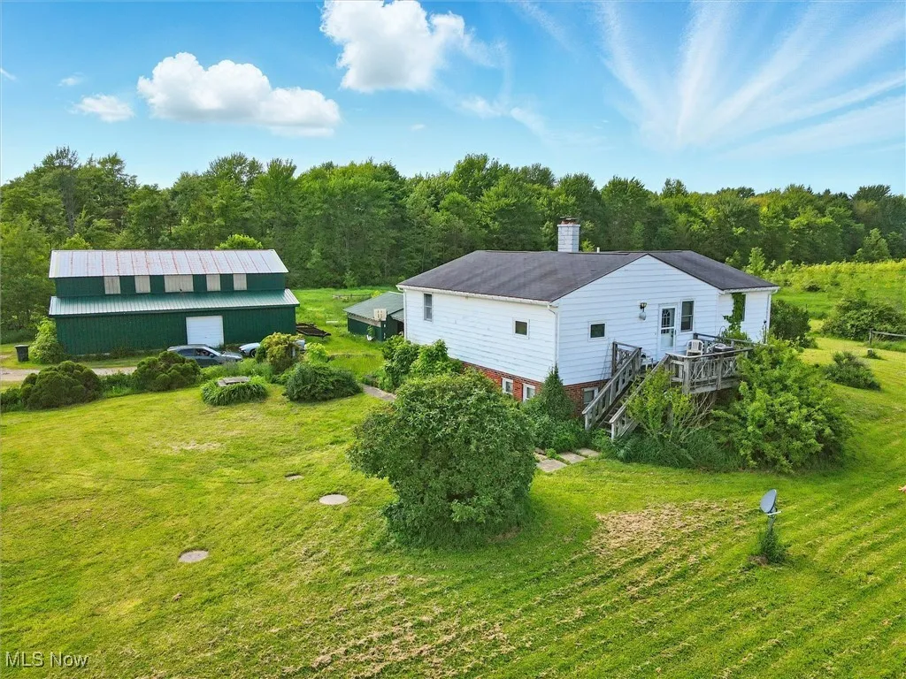 Aerial view of property and surrounding area featuring a forest
