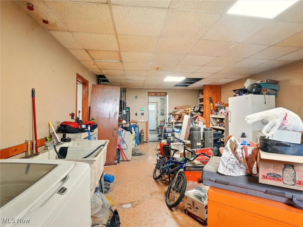 Miscellaneous room with a paneled ceiling, washer / dryer, and light flooring