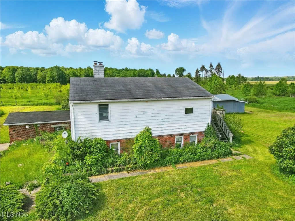 View of side of property with a lawn, a chimney, and​​‌​​​​‌​​‌‌​‌‌​​​‌‌​‌​‌​‌​​​‌​​ stairway