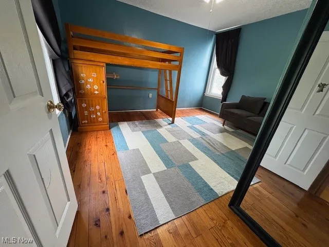 Bedroom featuring hardwood / wood-style floors and a textured ceiling