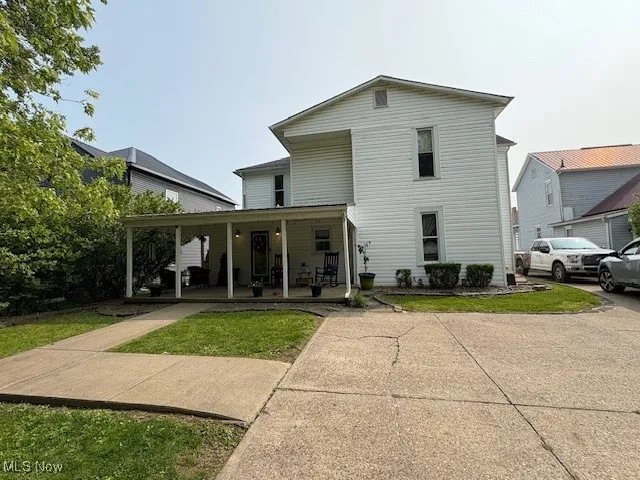 Back of house featuring a porch and a lawn