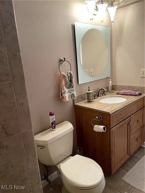 Bathroom featuring tile patterned flooring, toilet, and vanity