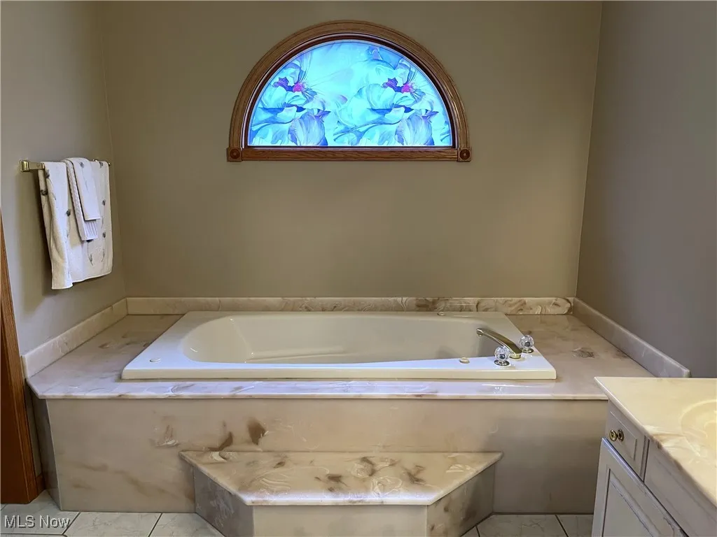 Full bath with vanity and a bath