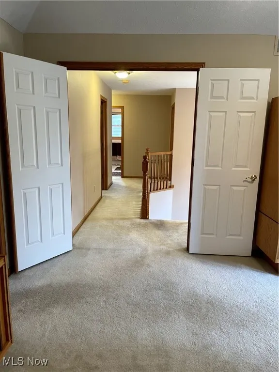 Spare room with light carpet and baseboards