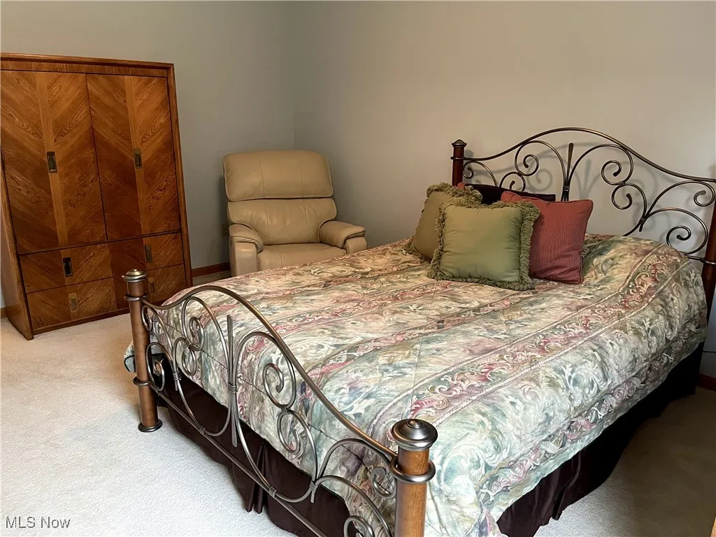 Bedroom featuring carpet and baseboards