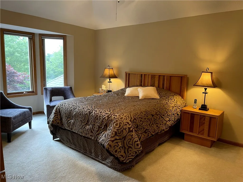Bedroom with light colored carpet and baseboards