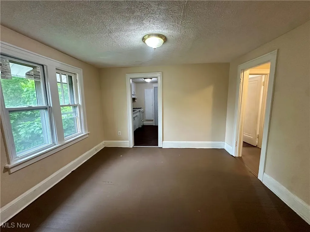Spare room featuring baseboards and a textured ceiling
