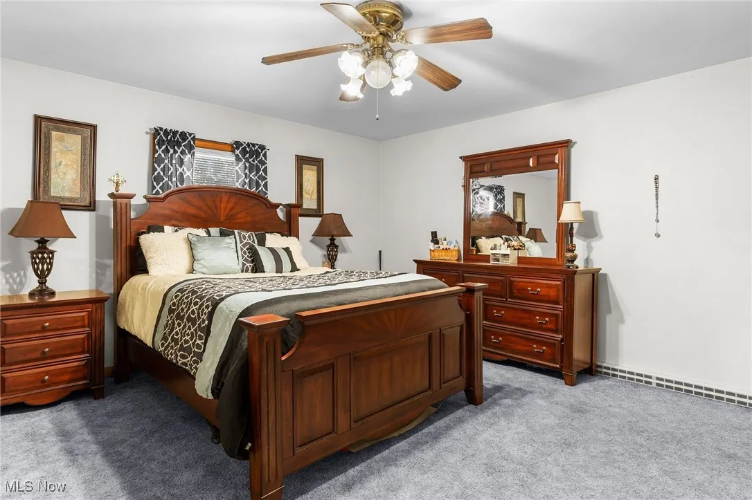 Bedroom with light colored carpet and a ceiling fan