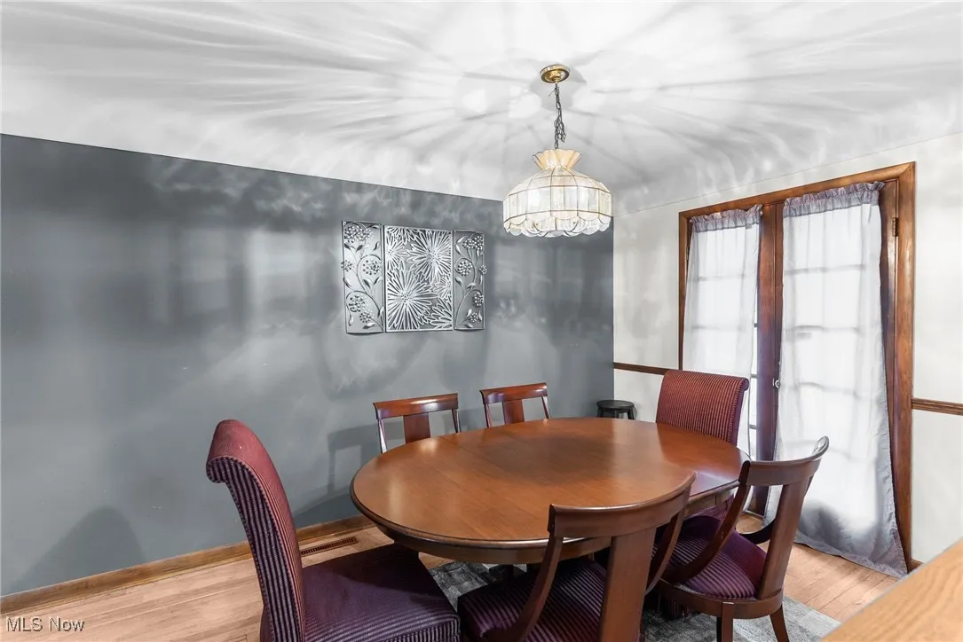 Dining room featuring light wood-type flooring and a chandelier