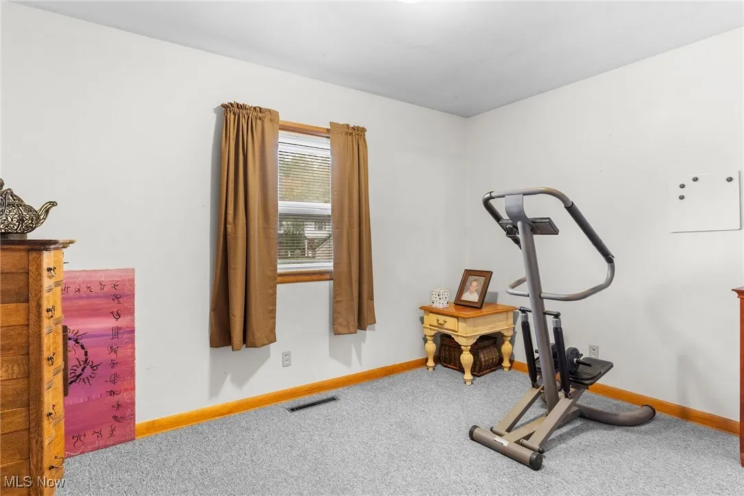 Exercise room with carpet floors and baseboards