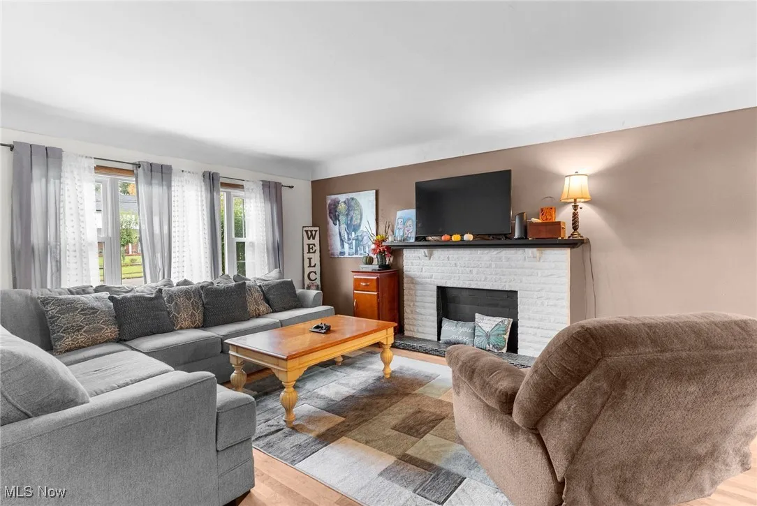 Living area with wood finished floors and a brick fireplace