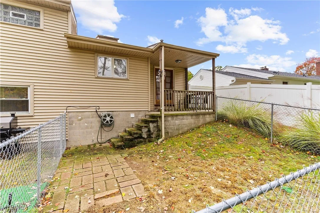 Rear view of house featuring covered porch and a fenced backyard
