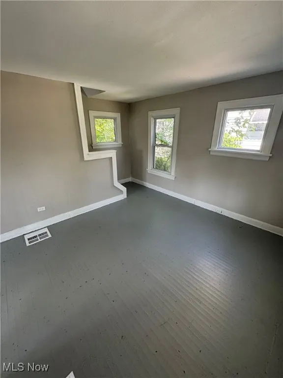 Empty room with baseboards and dark wood finished floors