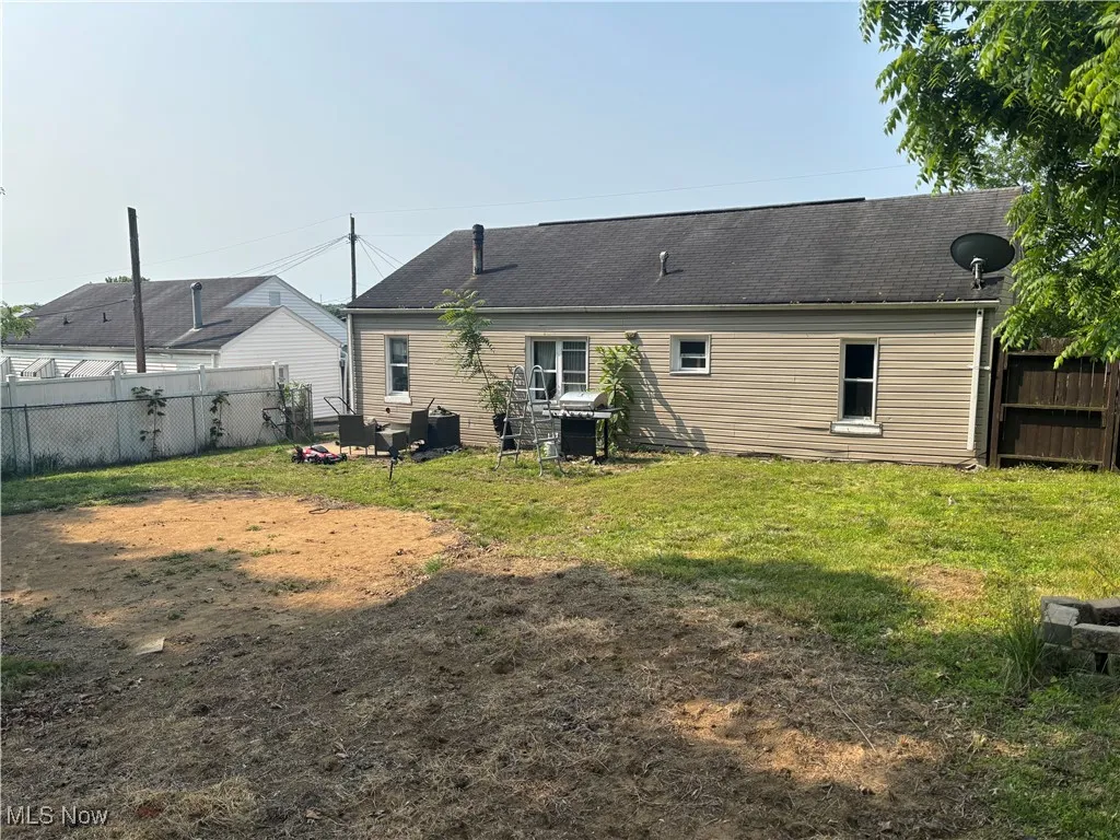 Back of house featuring roof with shingles