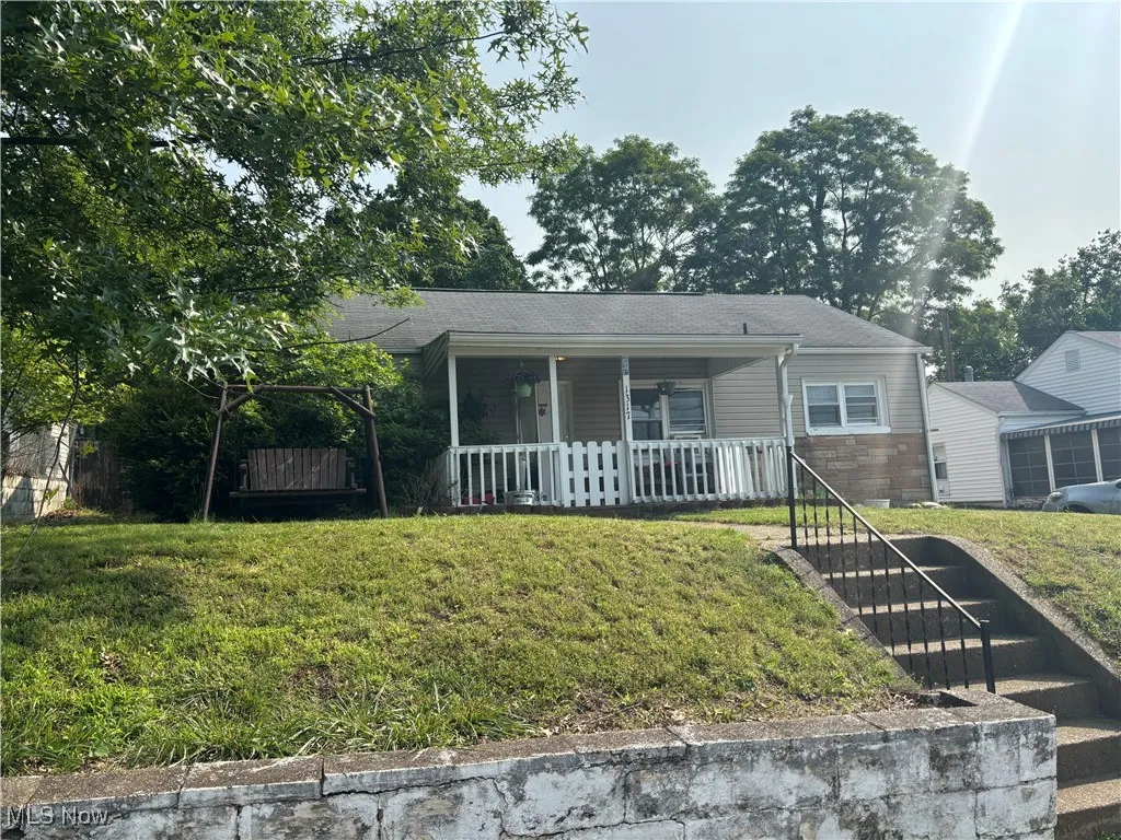 View of front of property featuring a porch and a front lawn