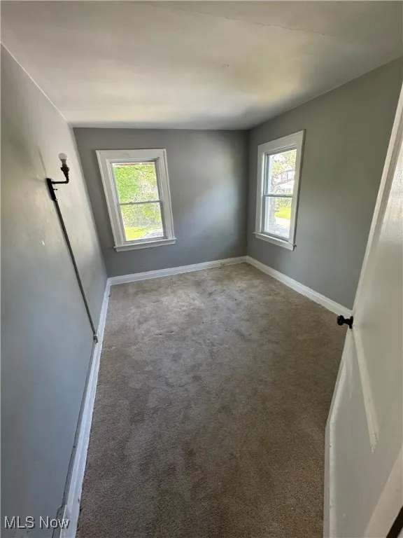 Unfurnished room featuring carpet flooring and baseboards
