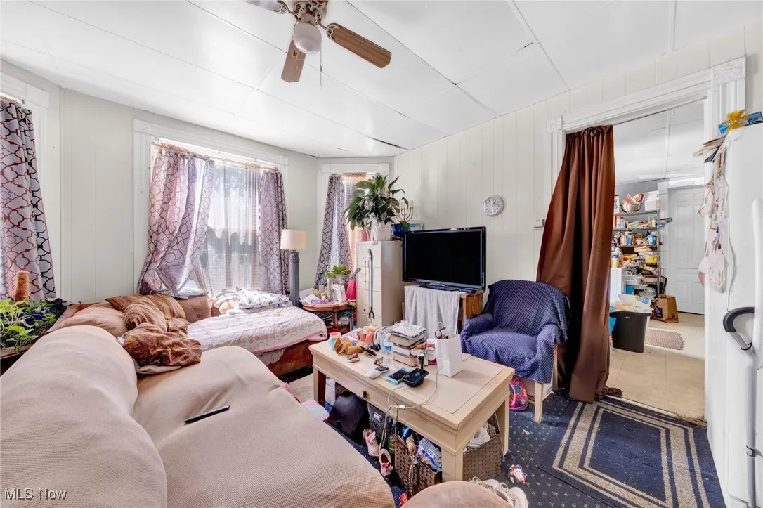 Living area featuring a ceiling fan and tile patterned flooring