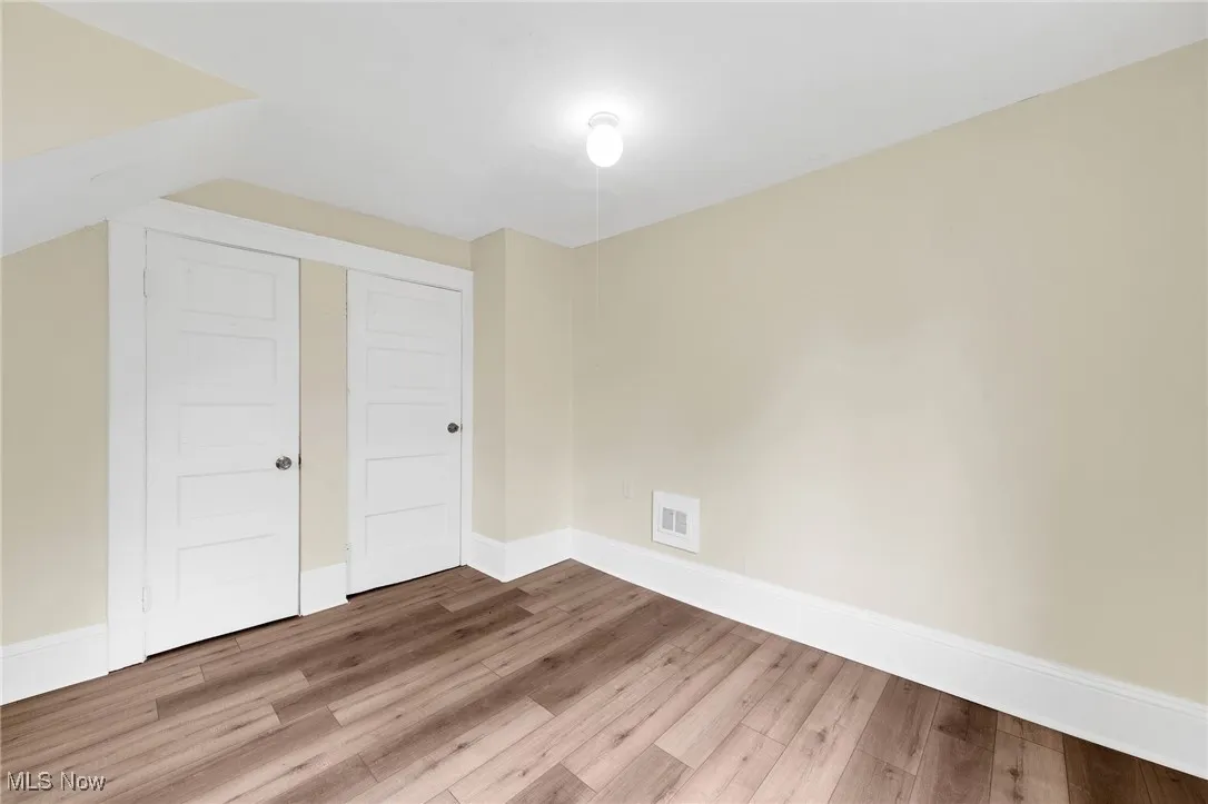 Unfurnished bedroom with wood finished floors and baseboards