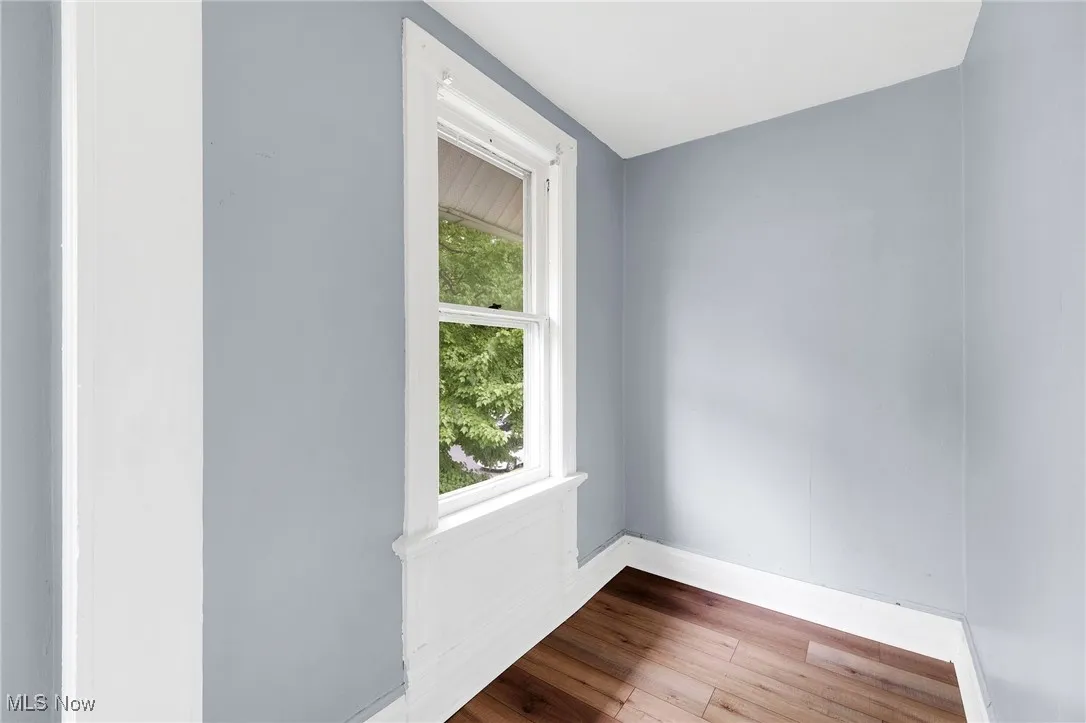 Unfurnished room with wood finished floors and baseboards