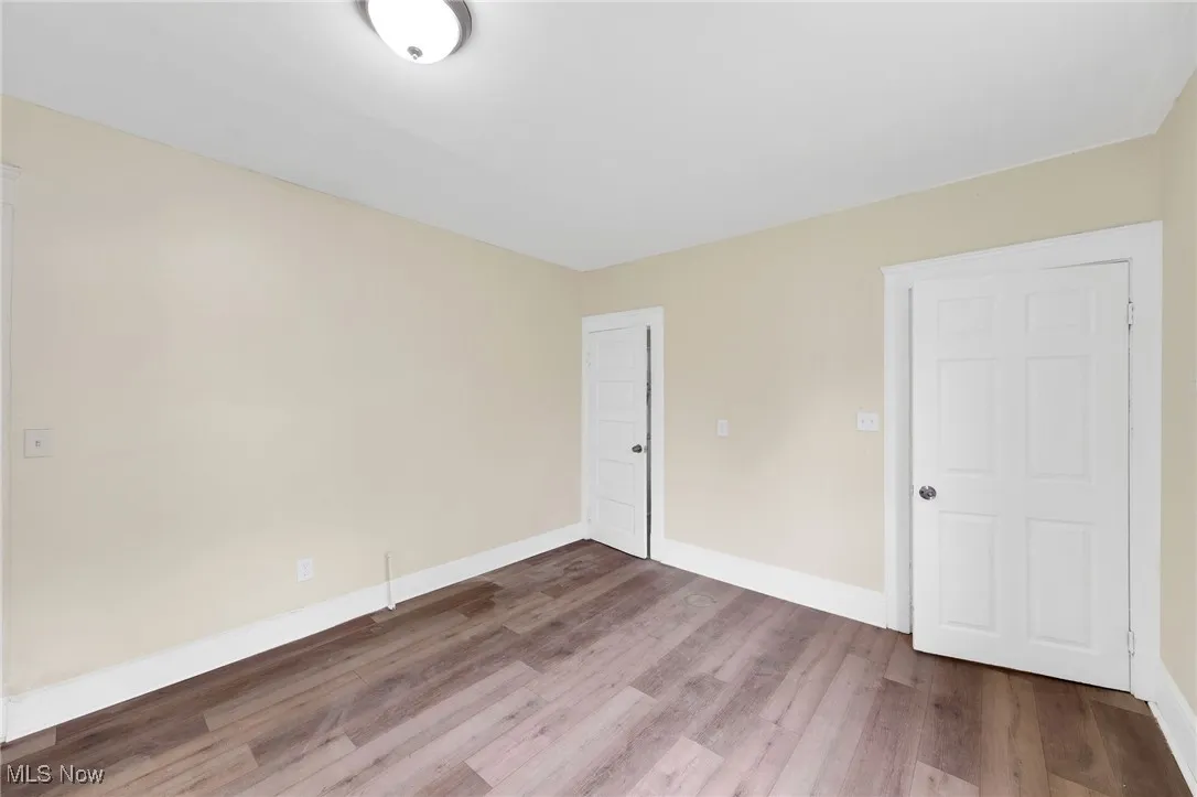 Unfurnished bedroom with wood finished floors and baseboards