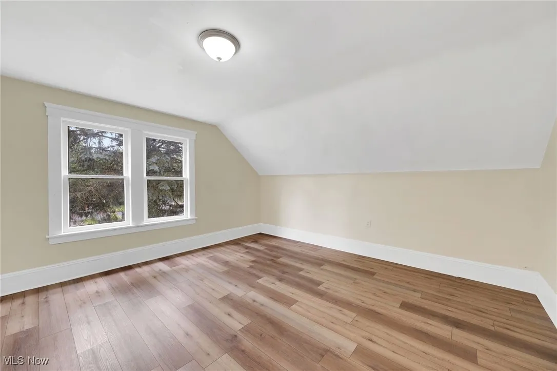 Bonus room with baseboards, hardwood / wood-style flooring, and vaulted ceiling