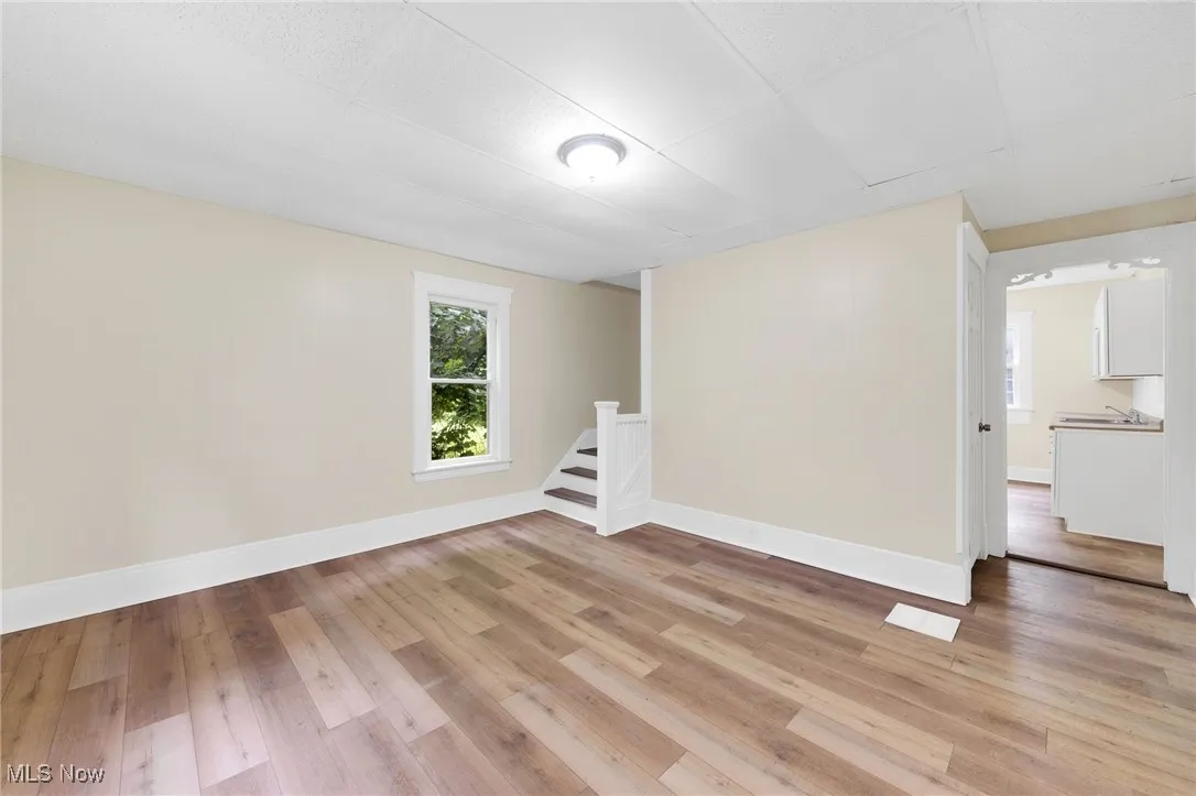 Unfurnished room with light wood-style floors and baseboards