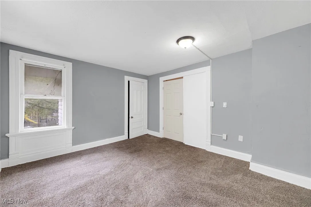 Carpeted empty room featuring baseboards