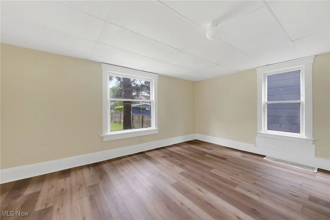 Spare room featuring wood finished floors and baseboards