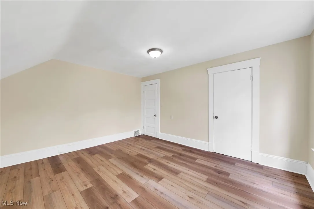 Bonus room featuring wood-type flooring, baseboards, and lofted ceiling