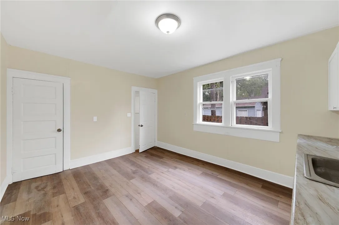 Unfurnished dining area featuring wood finished floors, baseboards, and a sink