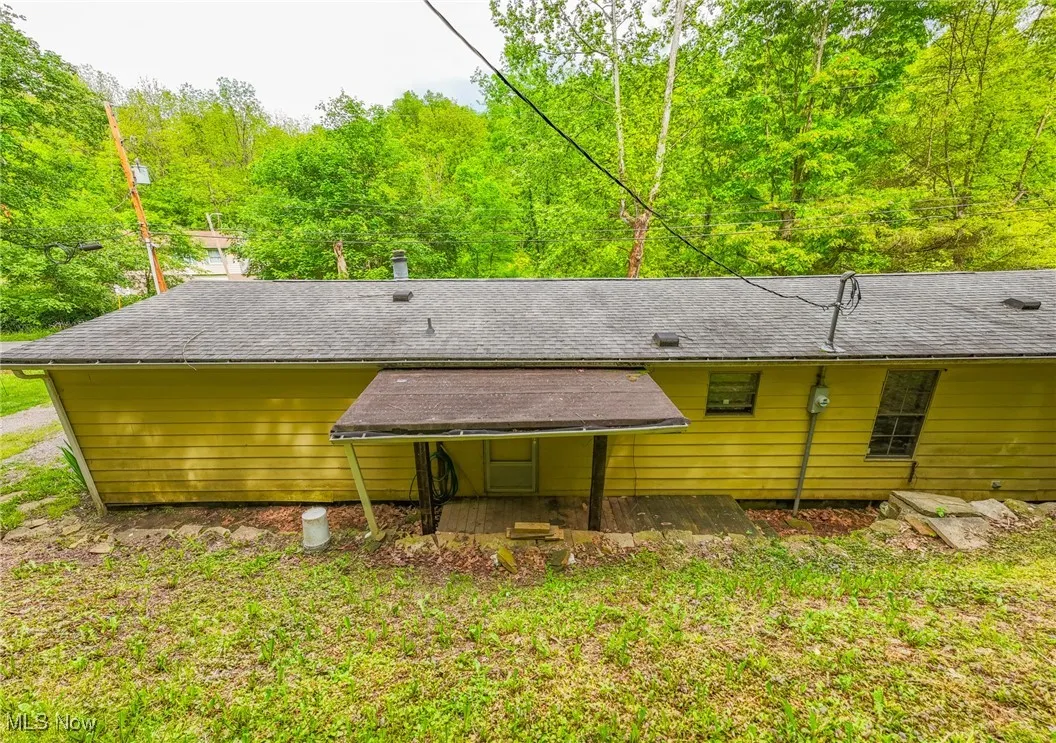 Rear view of house featuring a shingled roof