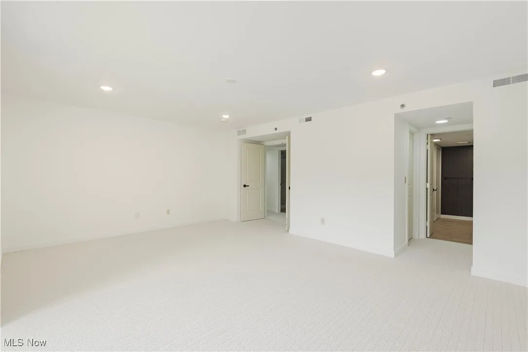 Spare room with light colored carpet, recessed lighting, and baseboards