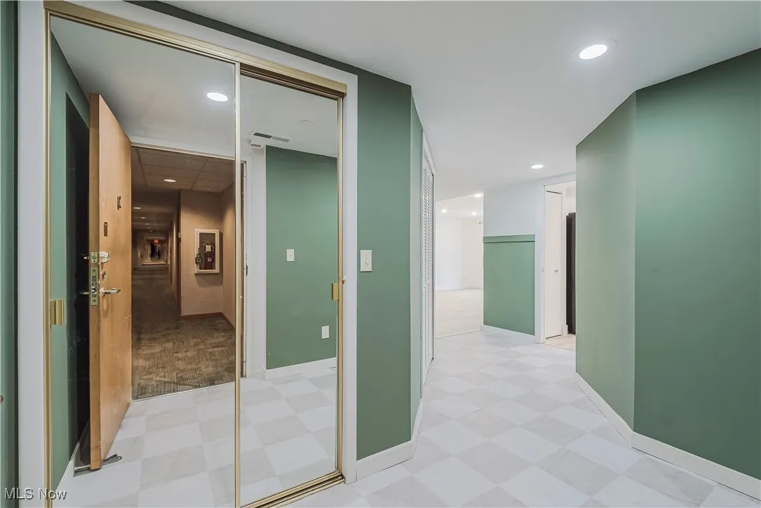 Hall with light flooring, baseboards, and recessed lighting