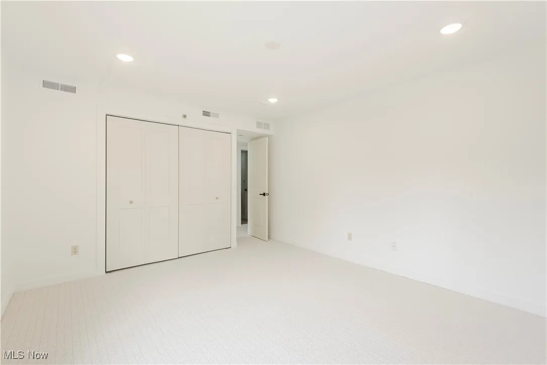 Unfurnished bedroom with light colored carpet, recessed lighting, a closet, and baseboards