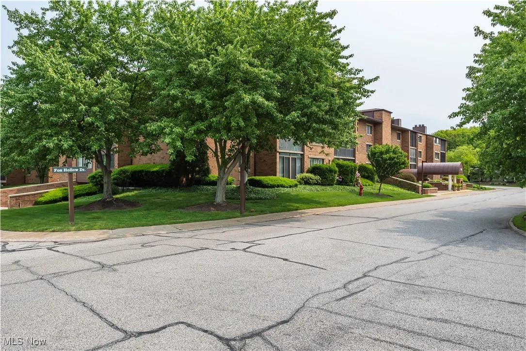 View of property hidden behind natural elements featuring a front lawn