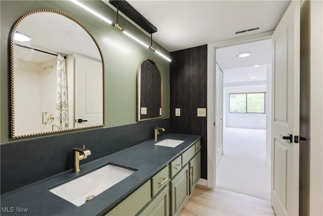 Bathroom with double vanity and wood finished floors