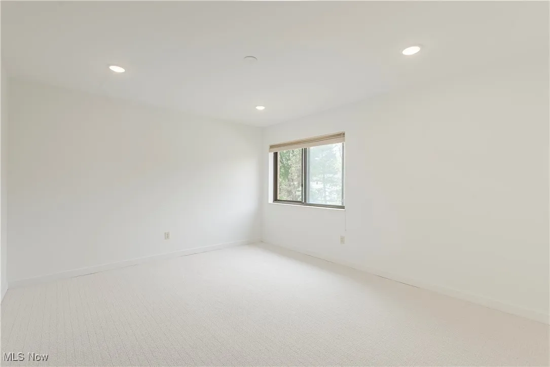 Empty room with recessed lighting, light colored carpet, and baseboards
