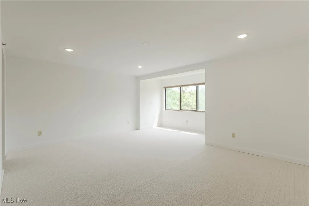 Empty room with light carpet, recessed lighting, and baseboards