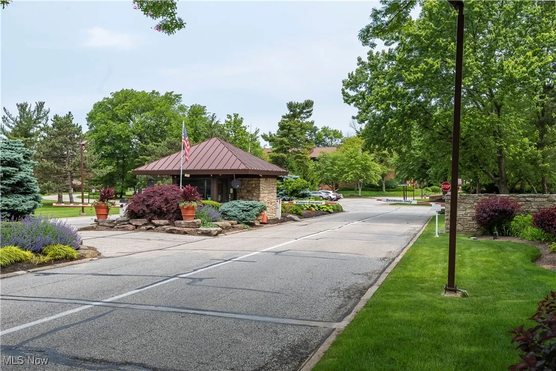 View of asphalt street featuring traffic signs, street lights, and curbs