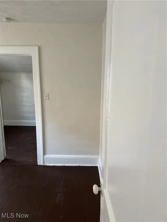 Hall with hardwood / wood-style flooring and baseboards